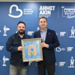 Balıkesir Büyükşehir Belediye Başkanı Ahmet Akın, ebru sanatçısı Osman Çemi'ye icazet takdimi sonrası hatıra fotoğrafı çektiriyor.