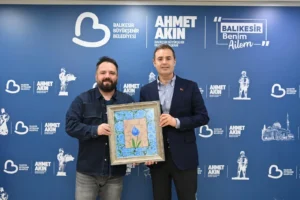 Balıkesir Büyükşehir Belediye Başkanı Ahmet Akın, ebru sanatçısı Osman Çemi'ye icazet takdimi sonrası hatıra fotoğrafı çektiriyor.