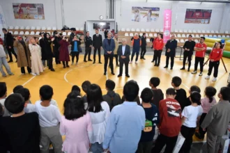 Kayseri Büyükşehir Belediye Başkanı Memduh Büyükkılıç, Sevgi Evleri'ndeki çocuklarla bayram etkinliğinde hediye veriyor.