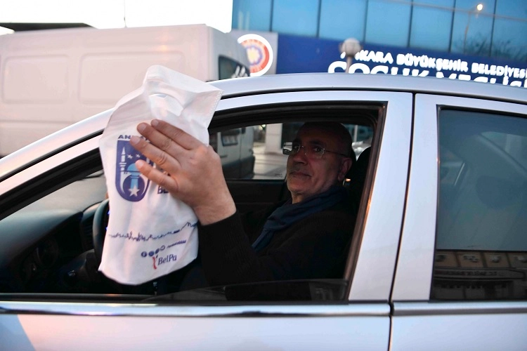 Ankara'da moto kuryelerin iftar vakti yolda kalanlara kumanya dağıttığı anı gösteren görsel