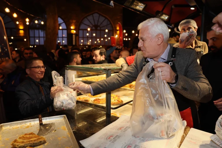 Bursa Büyükşehir Belediye Başkanı Mustafa Bozbey, Ramazan ayında Abdal Meydanı'nda düzenlenen sahur etkinliğinde vatandaşlara tahanlı pide ikram ediyor.