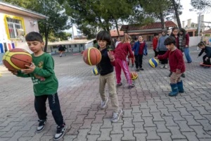 İzmir Büyükşehir Belediyesi'nin okullara spor malzemesi dağıtımını gösteren görsel