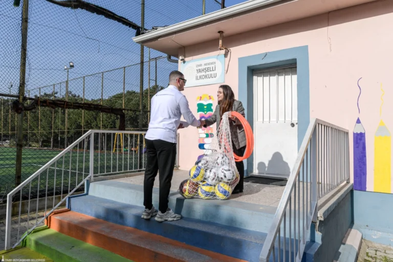 İzmir Büyükşehir Belediyesi'nin okullara spor malzemesi desteği kapsamında öğrencilere yardım ettiği görsel