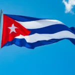 Küba bayrağı önünde konuşma yapan bir Kübalı yetkili