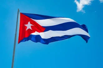 Küba bayrağı önünde konuşma yapan bir Kübalı yetkili