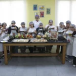 Mersin'de bir çocuk mutfak atölyesinde yemek yaparken gülümsüyor