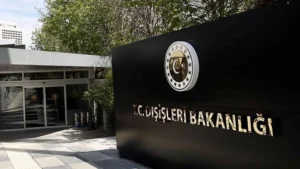 Dışişleri Bakanlığı binası önünde Türk bayrağı ve ateşkesi simgeleyen el sıkışma görseli.