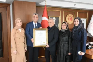 Ticaret Bakanı Ömer Bolat, Pakistanlı aileden ücret almayan esnaf Cemalettin Yılmaz'a Ahi Esnaf Beratı takdim ediyor.