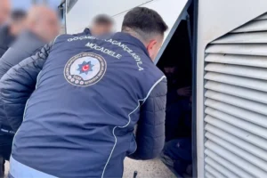 Yozgat'ta polis ekiplerinin düzenlediği göçmen kaçakçılığı operasyonunda yakalanan şahıslar ve araçlar.
