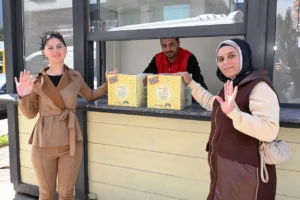 Mersin Büyükşehir Belediyesi'nin fenilketonüri hastalarına özel gıda kolisi dağıttığı anı gösteren görsel.