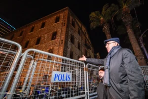 CHP'li Mahmut Tanal, İzmir Meslek Fabrikası önündeki polis barikatının plastik kelepçelerini penseyle kesiyor.