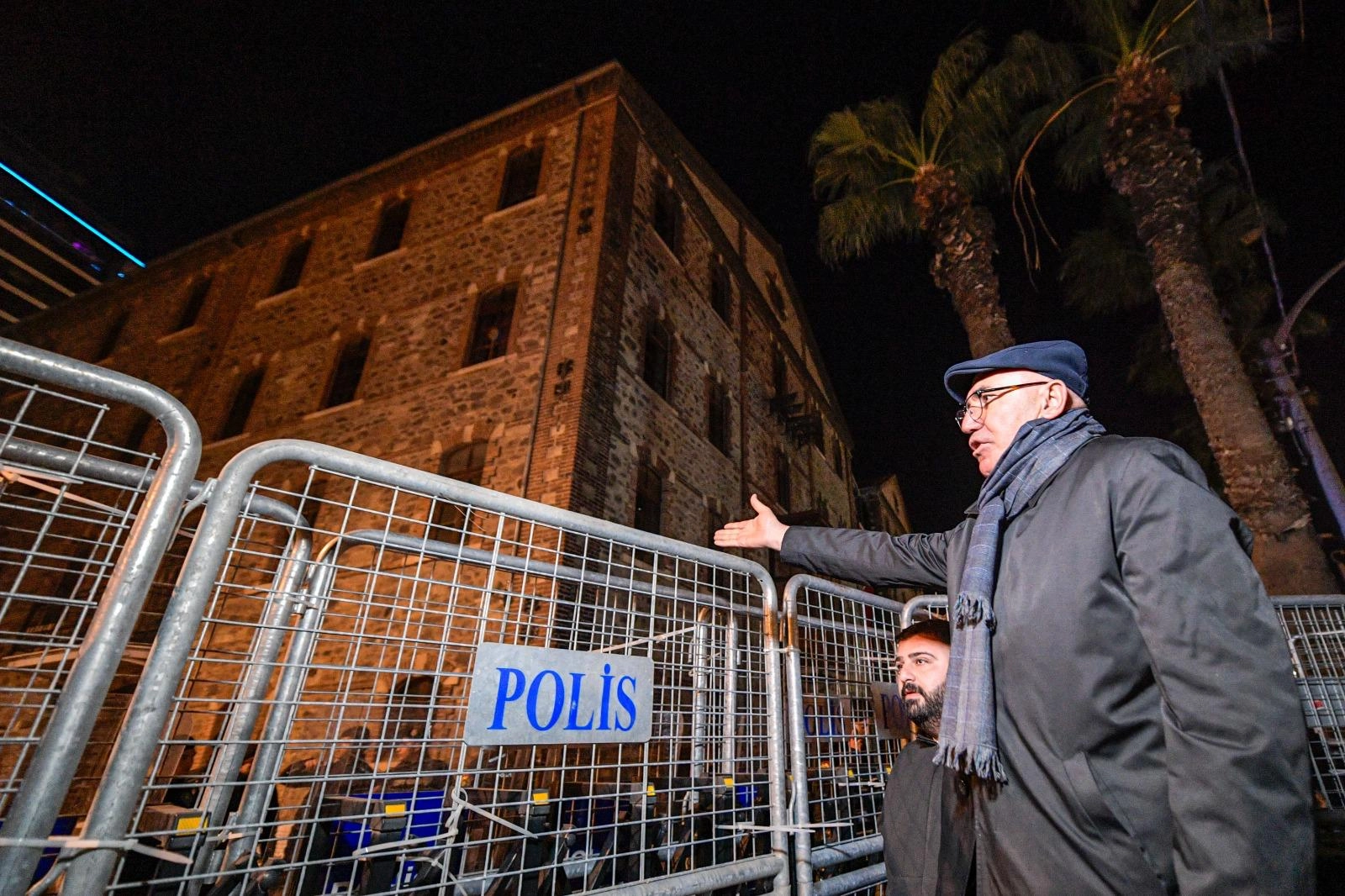 CHP'li Mahmut Tanal, İzmir Meslek Fabrikası önündeki polis barikatının plastik kelepçelerini penseyle kesiyor.