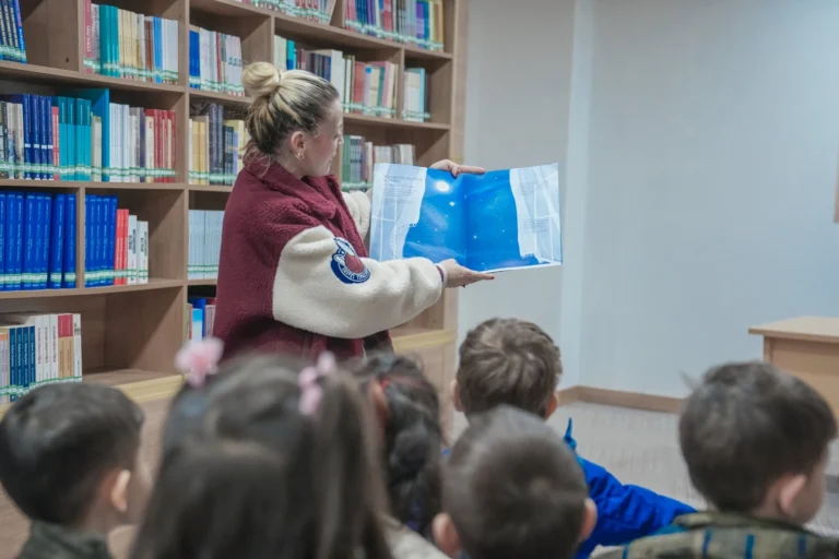 Keçiören'de minik öğrenciler kütüphane ziyareti sırasında kitaplara bakıyor