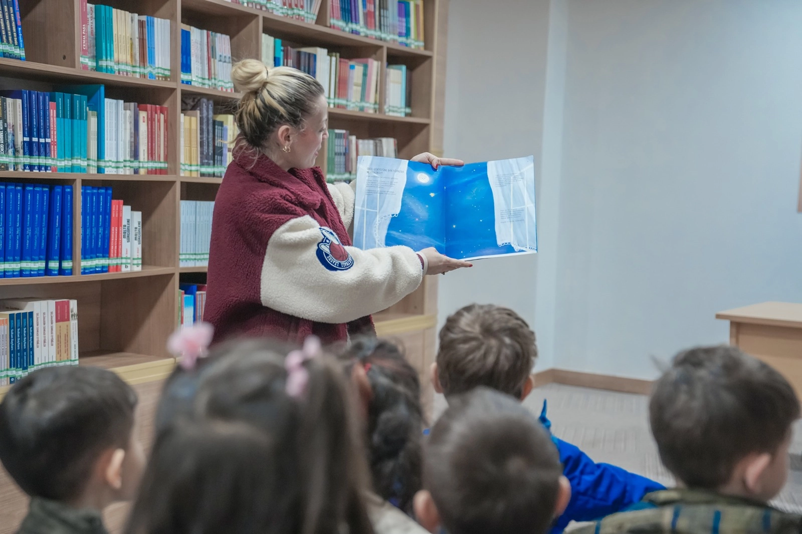 Keçiören'de minik öğrenciler kütüphane ziyareti sırasında kitaplara bakıyor