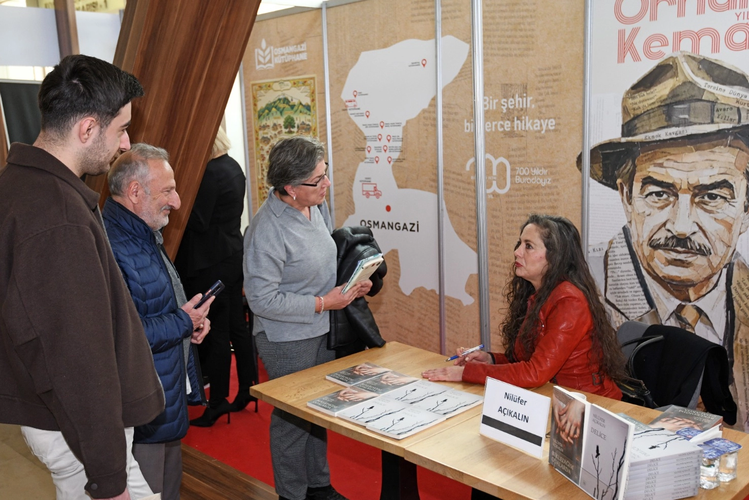 Nilüfer Açıkalın Bursa Kitap Fuarı Osmangazi Belediyesi standında okurlarıyla sohbet ediyor ve kitaplarını imzalıyor.
