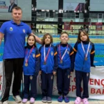 İnegöl Belediyespor yüzme takımı sporcuları madalyalarıyla birlikte gururla poz veriyor.