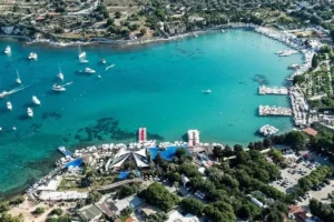 İzmir Büyükşehir Belediyesi logosu ve Ayayorgi Koyu manzarası