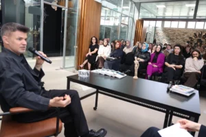 Moda tasarımcısı Cihan Nacar, Kocaeli Moda Akademisi'nde öğrencilere moda tasarımı ve kariyer hakkında ipuçları verirken.