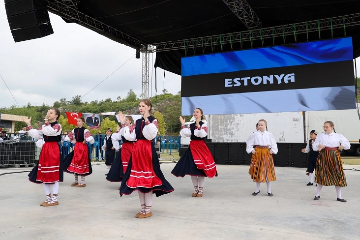 Antalya Uluslararası Çocuk Festivali'nde farklı ülkelerden gelen çocuklar geleneksel kıyafetleriyle dans ediyor.