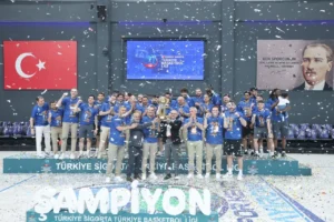 Çayırova Belediyesi Basketbol Takımı oyuncuları ve teknik heyeti, şampiyonluk kupasıyla zafer pozu veriyor.