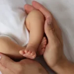 Anne ve bebeği kucaklaşırken, ek doğum izni başvurularının başladığı duyurusu yapılıyor.