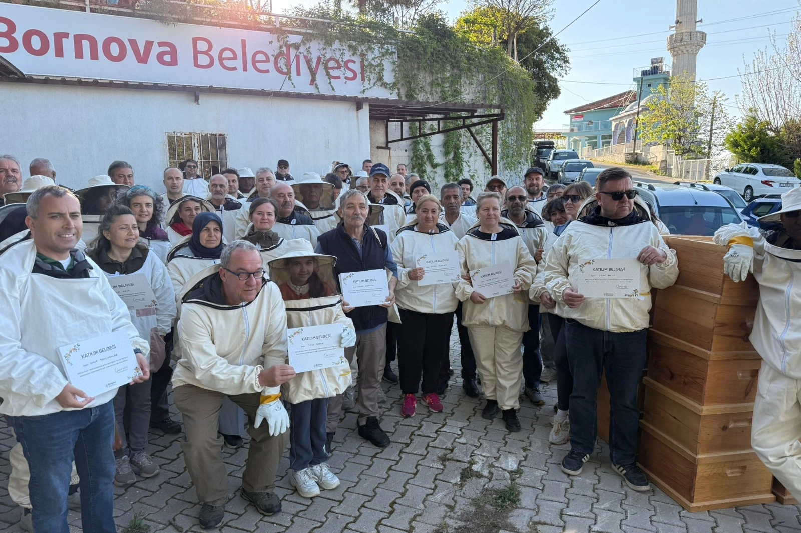Bornova Belediyesi arıcılık kursu mezunlarına arılı kovan ve ekipman dağıtımı yaparken çekilmiş fotoğraf