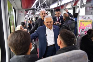 Kayseri Büyükşehir Belediye Başkanı Memduh Büyükkılıç tramvayla seyahat ederken vatandaşlarla sohbet ediyor.