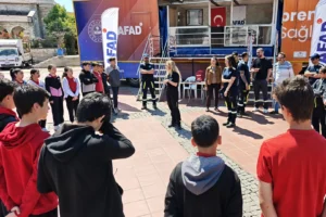 Aliağa'da deprem simülasyon tırı etkinliğinde vatandaşlar afetlere hazırlık eğitimi alıyor.
