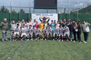 Öğretmenler ve Şeker Mevhibe Ortaokulu Yıldız Erkek Futbol Takımı Türkiye Şampiyonu kupasıyla poz veriyor.