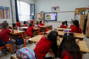 Sakarya'da SASKİ tarafından ilkokul öğrencilerine su tasarrufu eğitimi veriliyor, öğrencilere 'Su Müfettişi' rozeti takılıyor.