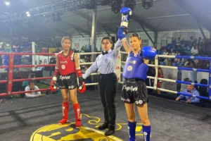 Adıyamanlı Berfin Polat, Muay Thai Dünya Şampiyonası'nda kürsüde bayrakla poz veriyor.