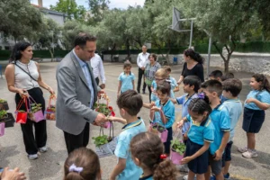 Bornova Belediye Başkanı Ömer Eşki, ilkokul öğrencilerine çilek fidesi dağıtımı etkinliğinde.