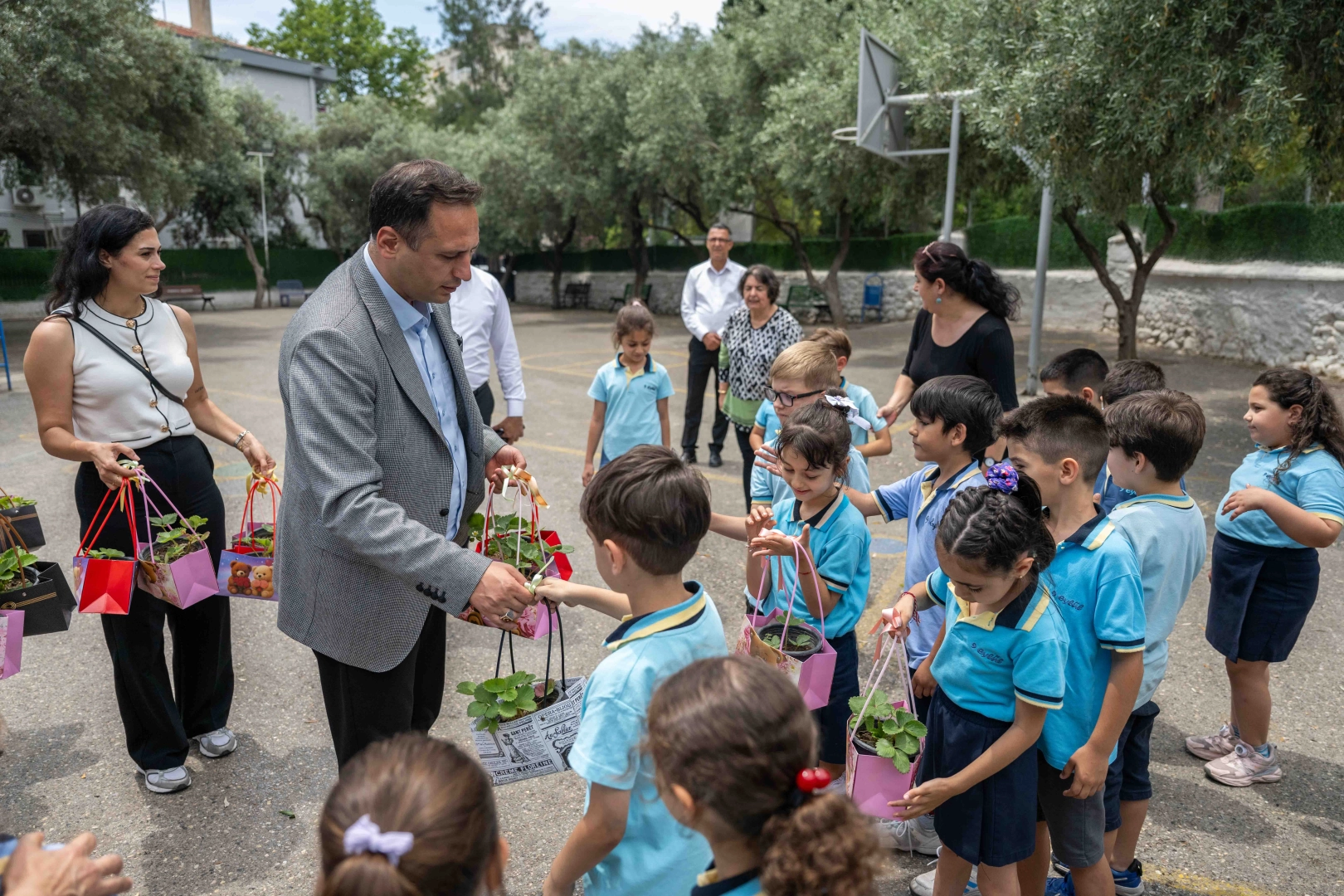 Bornova Belediye Başkanı Ömer Eşki, ilkokul öğrencilerine çilek fidesi dağıtımı etkinliğinde.