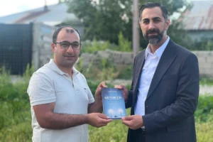 Ömer Tahtalı ve Barış Özmen, şiir kitabıyla birlikte objektiflere gülümsüyor.