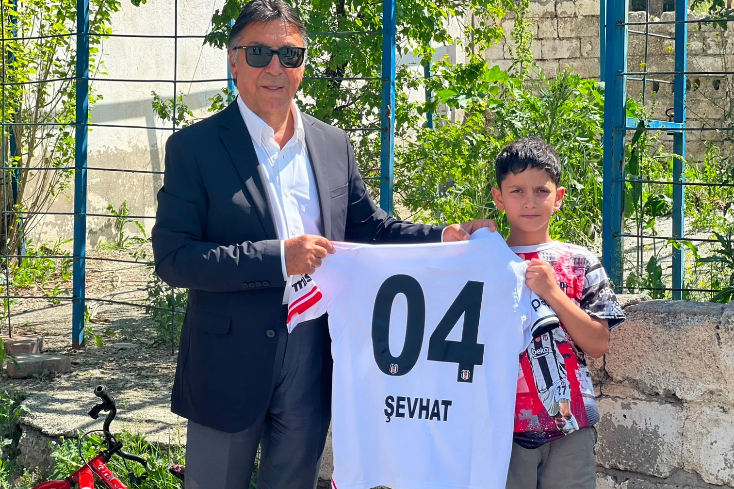 Ağrılı küçük Beşiktaş taraftarı Şevhat Arpacı, Seyit Ateş'in hediye ettiği formayla sevincini paylaşıyor.