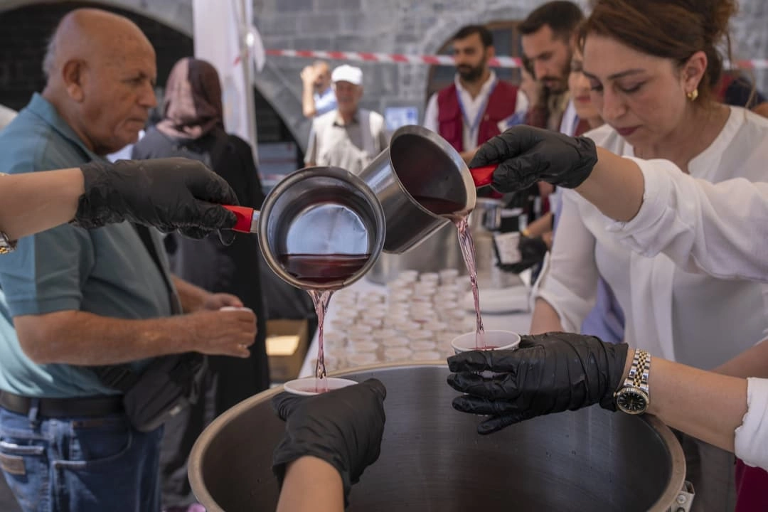 Diyarbakır Ulu Cami önünde vatandaşlara reyhan şerbeti ikram edilirken çekilmiş bir fotoğraf.
