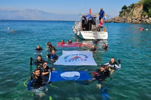 Antalya Muratpaşa'da Erenkuş Plajı'nda deniz dibi temizliği yapılıyor, dalgıçlar atıkları topluyor.