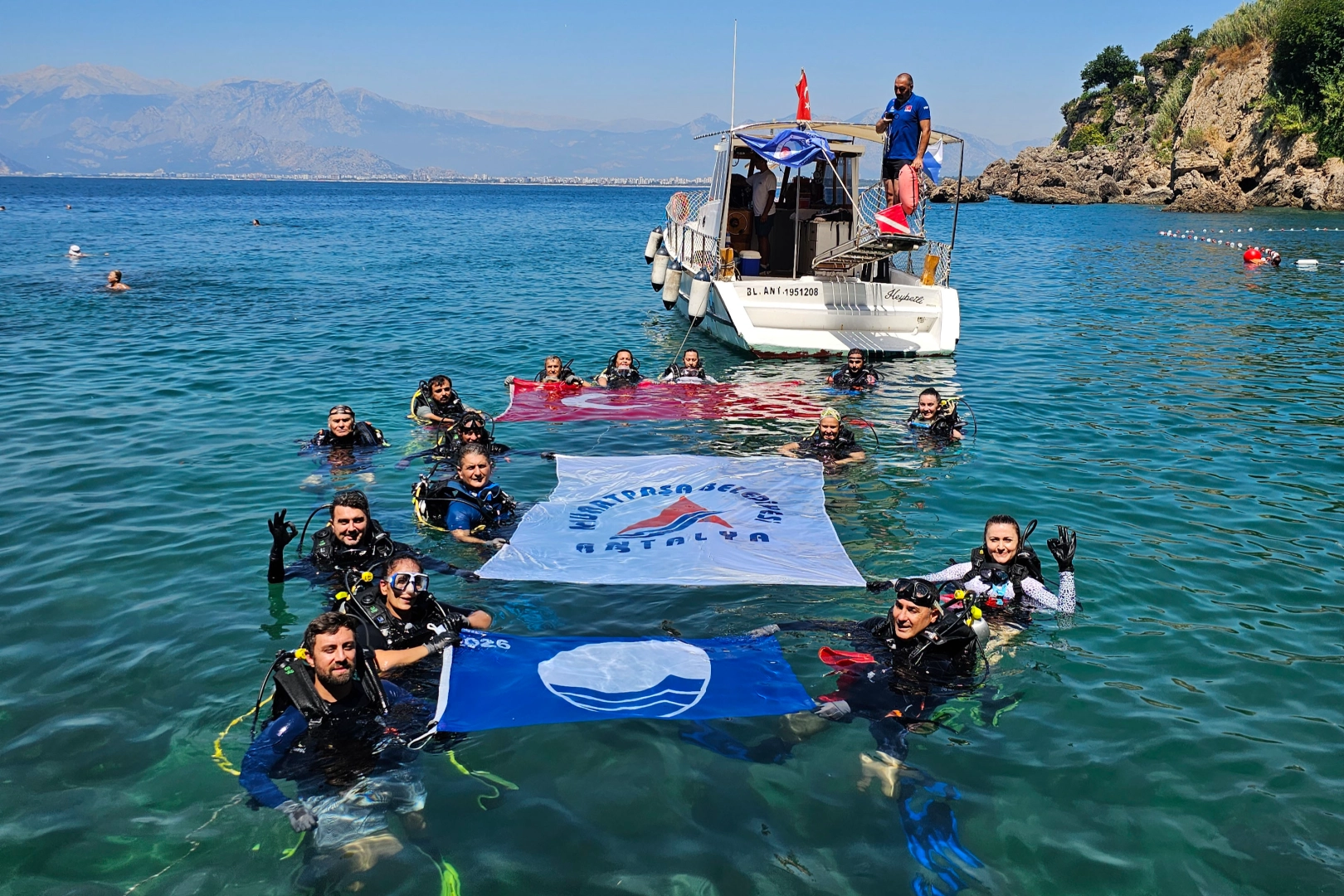 Antalya Muratpaşa'da Erenkuş Plajı'nda deniz dibi temizliği yapılıyor, dalgıçlar atıkları topluyor.