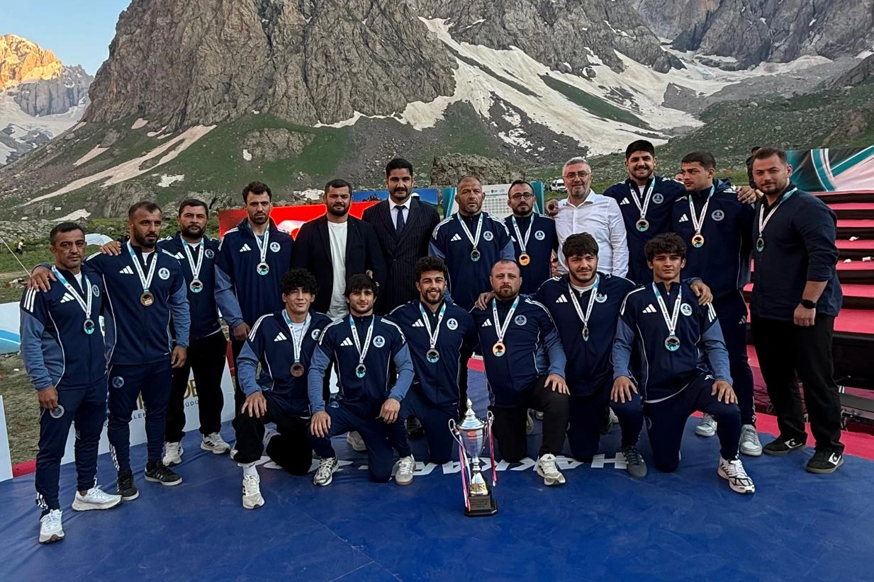 Kocaeli Büyükşehir Belediyesi Kağıtsporlu güreşçi, judocu ve karateci sporcuların kürsüde madalya alırken çekilmiş toplu fotoğrafı.
