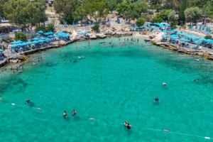 Mersin'in gözde plajlarında güneşlenen ve denizin tadını çıkaran mutlu tatilciler