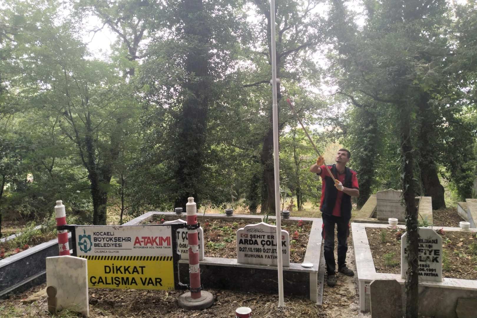 Kocaeli Hakkaniye Şehitliği'nde Büyükşehir Belediyesi tarafından yapılan bayrak direği onarımı ve bayrak değişimi
