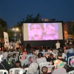 Osmangazi Belediyesi tarafından Başaran Mahallesi'nde düzenlenen yazlık sinema etkinliğinde çocuklar film izliyor.