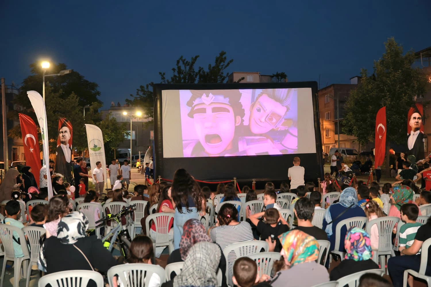 Osmangazi Belediyesi tarafından Başaran Mahallesi'nde düzenlenen yazlık sinema etkinliğinde çocuklar film izliyor.