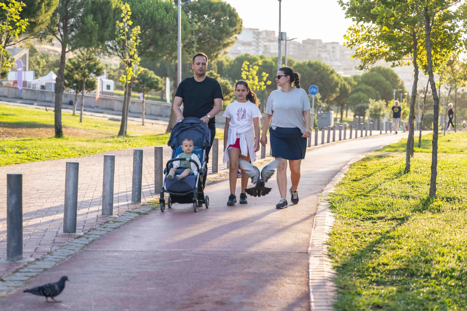 Bornova Belediye Başkanı Ömer Eşki, eşi ve çocuklarıyla yeşil alanda yürüyüş yaparken